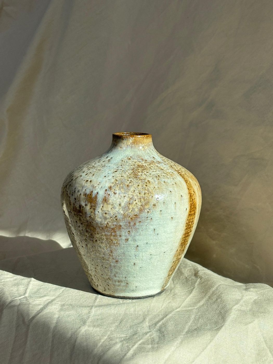 Tall speckled stoneware vase with narrow neck