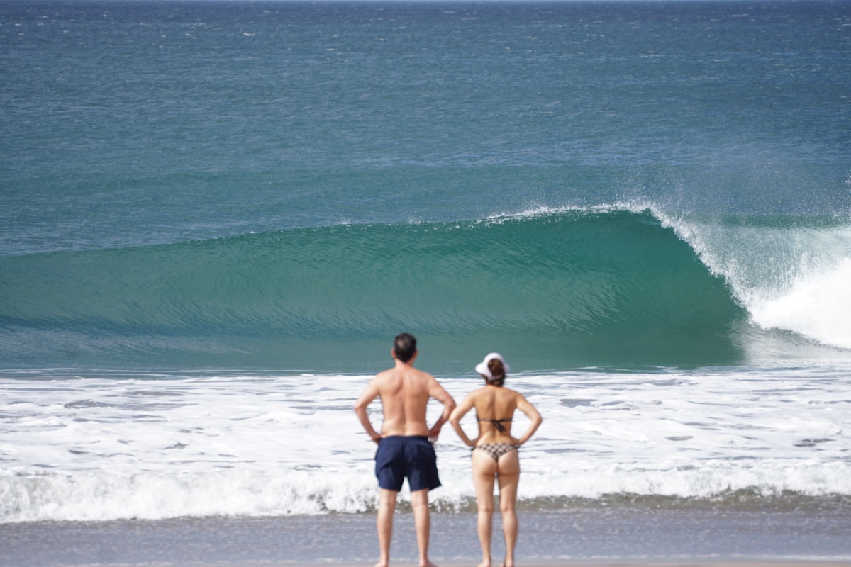 Couple watching a barreling wave